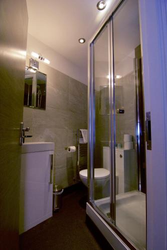 a bathroom with a shower and a toilet and a sink at Harrogate Lifestyle Luxury Serviced ApartHotel in Harrogate