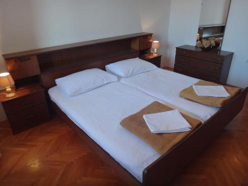 a bedroom with a large bed with two towels on it at Apartments Pavlov in Tisno