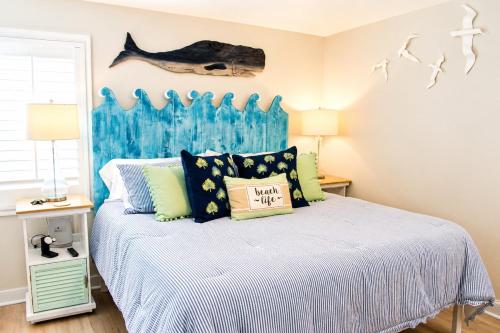 a bedroom with a bed and a fish on the wall at Bright Coastal Condo in Saint Simons Island