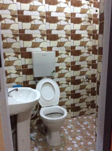 a bathroom with a toilet and a sink at RockView Hotel in Tongo