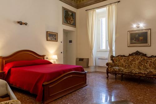 a bedroom with a red bed and a couch at B&B del pozzo in Narni