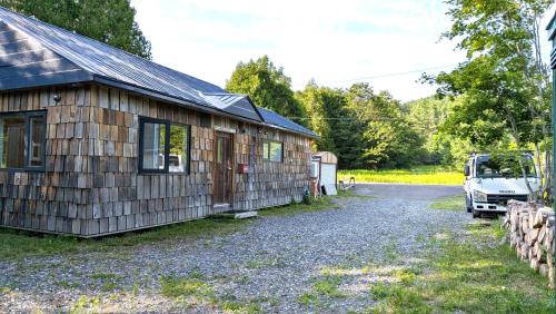 a barn with a car parked next to it at 暮らす宿ソラプチ Sorapchi Cabin in Ochiai