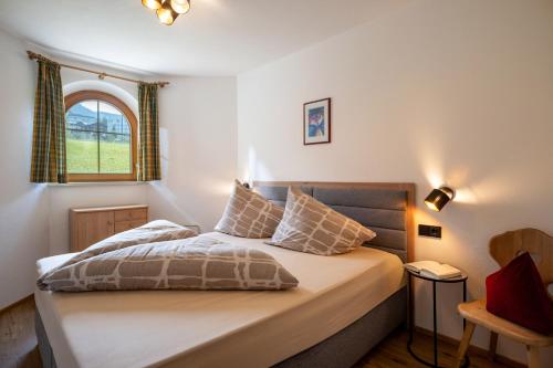 a bedroom with a large bed with a window at Appartements Sonntal Einkehr in Fieberbrunn