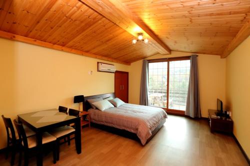 a bedroom with a bed and a table and a window at 솔향기펜션 in Hongcheon