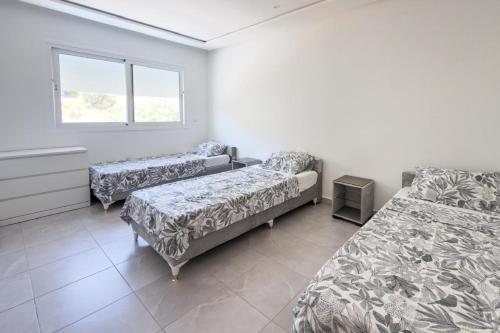 a hospital room with two beds and a window at Reda Appartements Al Hoceima in Al Hoceïma