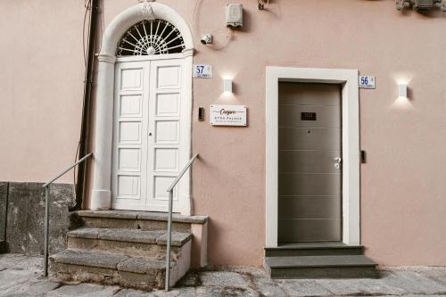 a pink building with a white door and stairs at Corsaro Etna Palace in Motta SantʼAnastasia