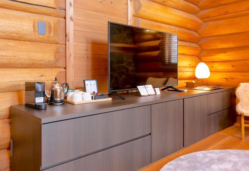 a living room with a flat screen tv on a wooden wall at Villa Rusutsu in Rusutsu