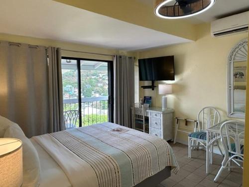 a bedroom with a bed and a balcony at The Green Iguana Hotel in Charlotte Amalie