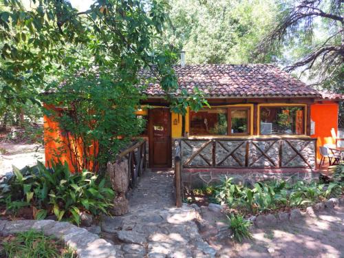 a small house in the middle of a garden at cabañas spa el petrel in San Javier