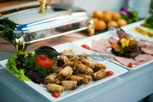 a plate of food with meat and vegetables on a table at Splendid Hotel & Spa in Hanoi