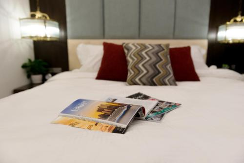 a bed with a book and magazines on it at Splendid Hotel & Spa in Hanoi