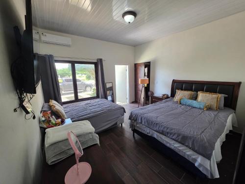 a bedroom with two beds and a flat screen tv at Luana's 0601 in Choluteca