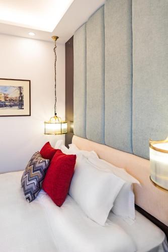 a bedroom with a bed with red and white pillows at Splendid Hotel & Spa in Hanoi
