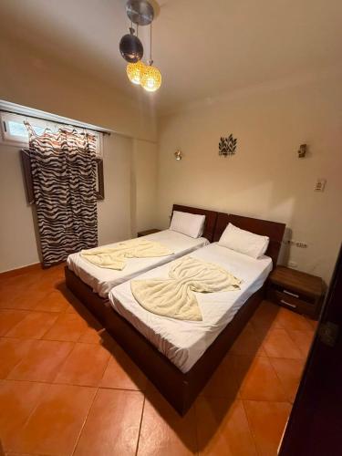 a bedroom with a large bed with white sheets at Porto Sokhna Aprtment Pool View - MR in Ain Sokhna