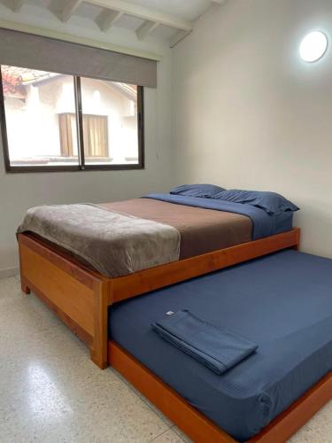 two beds in a room with a window at 10 Caribe, tranquilidad y Casa Familiar in Rodadero