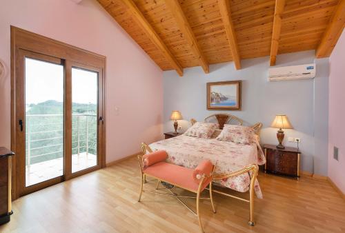 ein Schlafzimmer mit einem Bett und einem großen Fenster in der Unterkunft Villa Kaloudis in Kolymbia