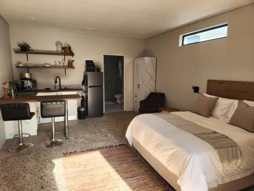 a bedroom with a bed and a kitchen with a sink at Windsor Cottage in Avondale