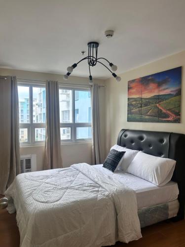 a bedroom with a bed and two windows at Davao Cozy Condo T6 unit 2 in Davao City