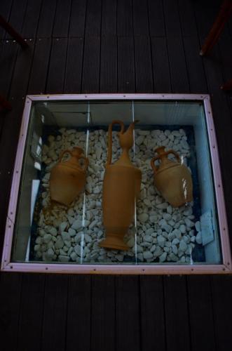 a display of three vases and rocks on a table at Kalathos Sun Hotel in Kalathos