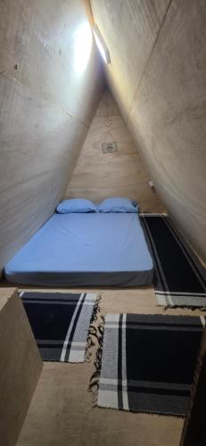 a small bed in a small room in a tent at Camping & Glamping For All in Itaúnas