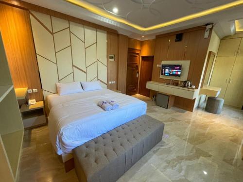 a bedroom with a large bed and a television at Alzetta Hotel by Abiza in Timuran