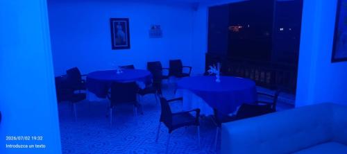 a room with tables and chairs with blue lights at HotelSueñosCafeteros in Montenegro
