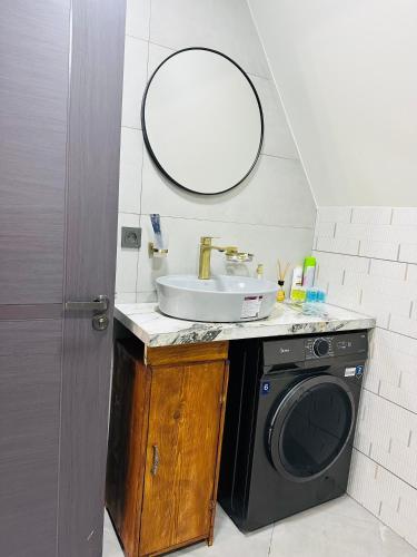a bathroom with a sink and a washing machine at Hiyadel balcony in Sadgeri