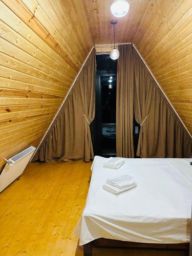 a bedroom with a bed in a wooden room at Hiyadel balcony in Sadgeri