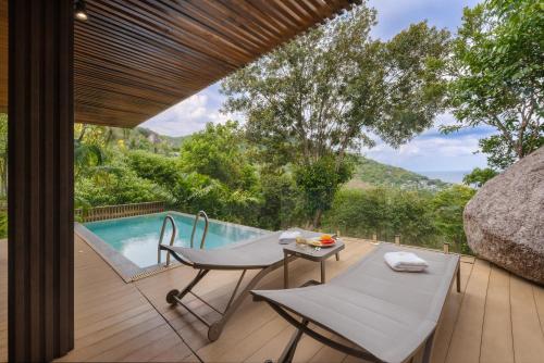 a patio with a table and chairs next to a pool at Tanote Villa resort, Koh-Tao in Ko Tao