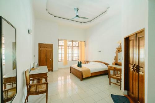 a bedroom with a bed and a table and chairs at Uns Hotel - Bali in Legian