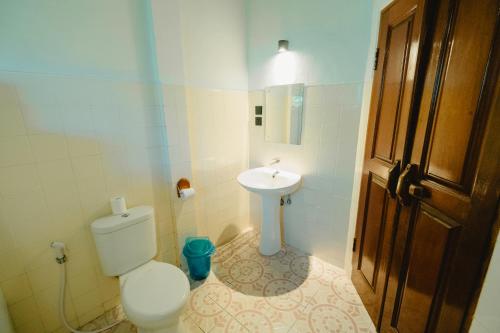 a bathroom with a toilet and a sink at Uns Hotel - Bali in Legian
