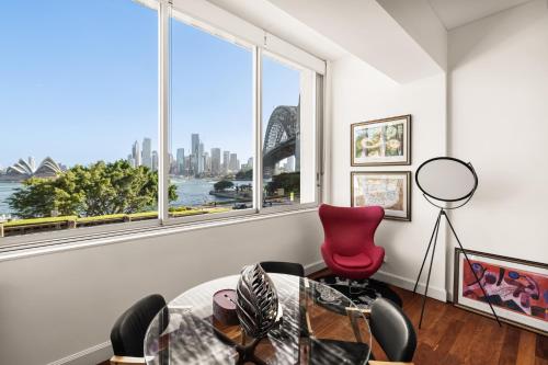 a room with a table and chairs and a large window at Opera House Retreat - Opera House & Bridge View in Sydney