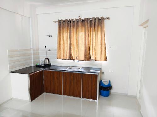 a small kitchen with a sink and a window at Harichandhanam stay in Guruvāyūr
