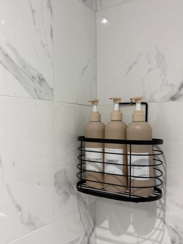 a shelf with three bottles on it in a bathroom at Cosy T1 Bis climatisé in Toulouse