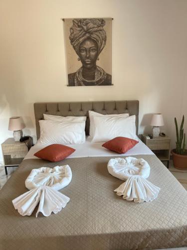 a large bed with two pillows on it with a statue at Giouli's Maison in Eretria
