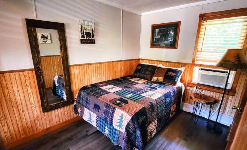 a small bedroom with a bed and a mirror at Maple Grove Lodging in Finland
