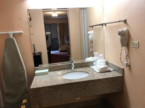 un baño con encimera con lavabo y teléfono en Travel Inn, en Broadview