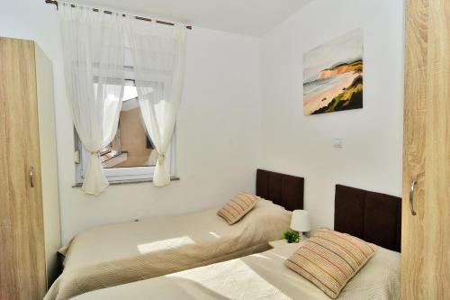 a bedroom with two beds and a window at Apartments Sanja in Zaton