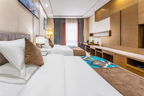 a hotel room with two beds and a television at East Station Boya Hotel in Guangzhou
