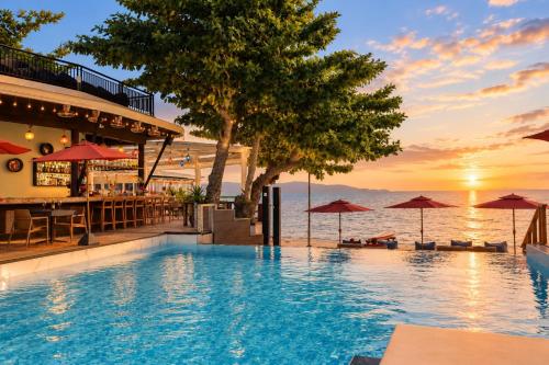 a swimming pool with a view of the ocean at sunset at Sunset Beach Hotel - Adults Only in Haad Rin