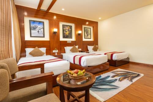 a hotel room with two beds and a table at Aryatara Kathmandu Hotel in Kathmandu