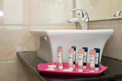 a pink toothbrush holder sitting next to a sink at Aryatara Kathmandu Hotel in Kathmandu