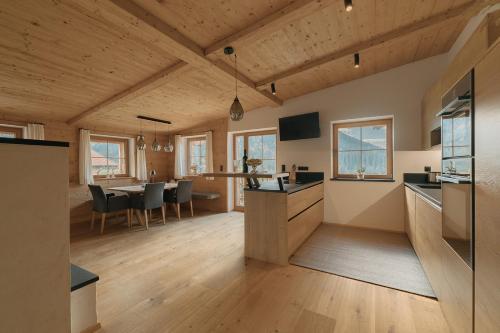 a kitchen and living room with a table and chairs at Chalet Tuxer in Achenkirch