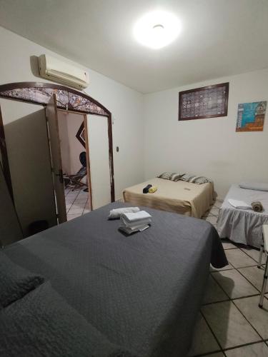 a room with two beds and a refrigerator in it at durmaaquislz2 in São Luís