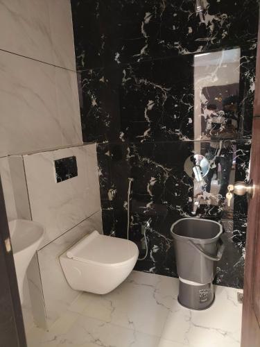 a black and white bathroom with a toilet and a sink at Hotel 9Eleven & Cafe in Barnāla