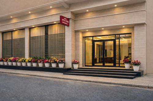 a building with pots of flowers in front of it at Hotel Almora Suites - Near Delhi Airport in New Delhi