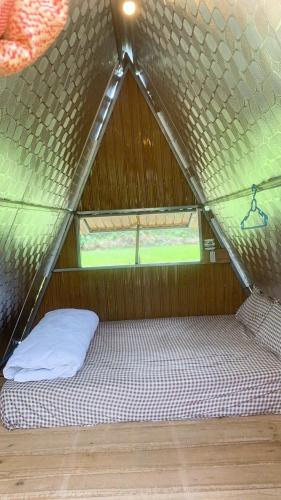 a bed in a tent with a window at Aluoi Homestay in Hue