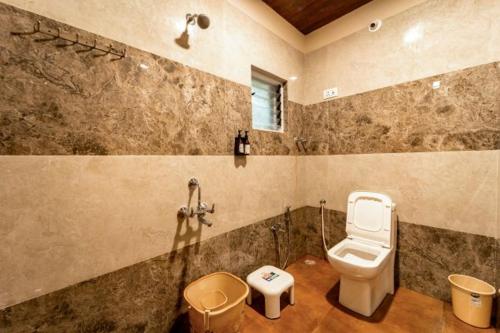 a bathroom with a toilet and a sink at Rain Forest Jungle Stay in Kurandi