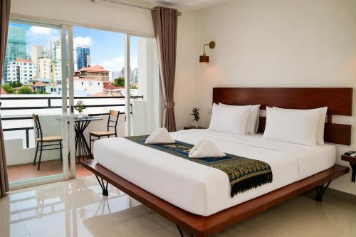 a bedroom with a large bed and a balcony at Bliss & Beats Hostel in Phnom Penh
