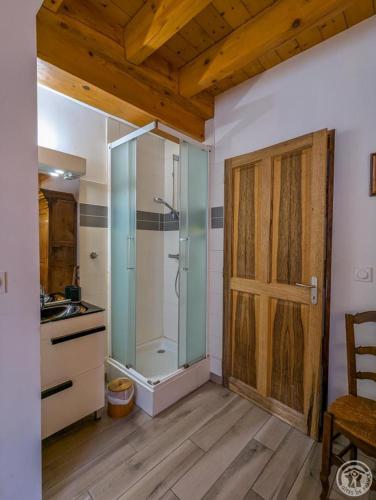 a bathroom with a shower and a sliding door at Le castillon in Marignac